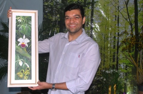 O jornalista Luiz Esteves exibe a tela "Cascata de orquídeas".