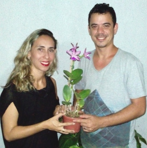 Luiz recebe a orquídea das mãos da vice-presidente da ACEO, Juliana Coelho